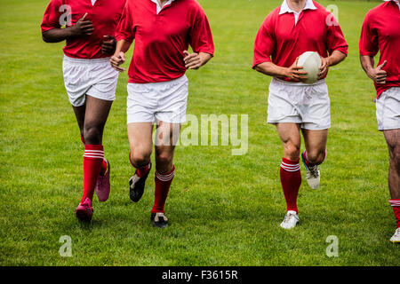 Jogging avec des joueurs de rugby ball Banque D'Images