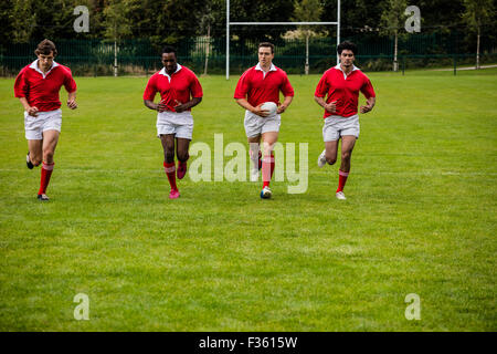 Jogging avec des joueurs de rugby ball Banque D'Images