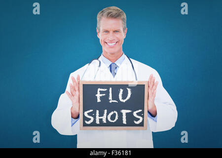 Image composite de portrait of smiling male doctor holding blank slate Banque D'Images