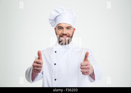 Portrait of a happy male chef cuisinier showing Thumbs up isolé sur fond blanc Banque D'Images
