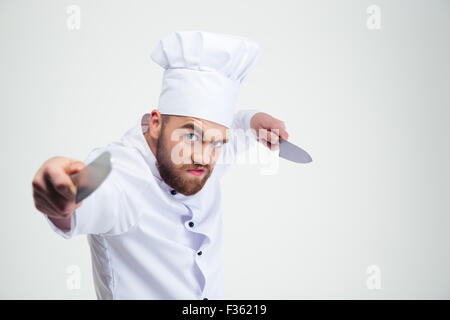 Portrait de chef cuisinier en colère couteaux holding isolé sur un fond blanc Banque D'Images