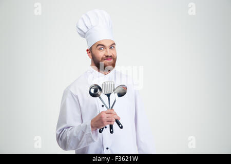 Portrait d'un drôle de male chef cook holding cuillères isolé sur fond blanc Banque D'Images
