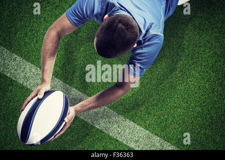 Image composite de rugby player se trouvant à l'avant avec ball Banque D'Images