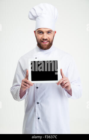 Portrait of a smiling male chef cuisinier montrant l'écran de l'ordinateur tablette blanc isolé sur fond blanc Banque D'Images