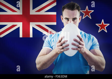 Image composite de rugby player looking at camera with ball Banque D'Images