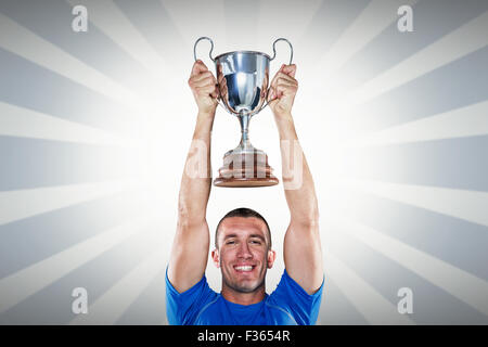 Image composite de portrait of smiling rugby player holding trophy Banque D'Images