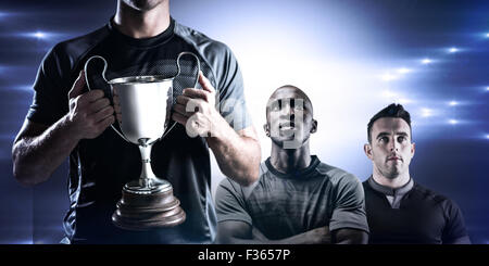 Image composite de rugbyman victorieux holding trophy Banque D'Images