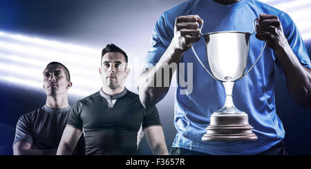 Image composite de mid section de sportif holding trophy Banque D'Images