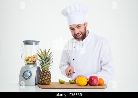 Portrait of a happy male chef couper des fruits isolé sur fond blanc Banque D'Images