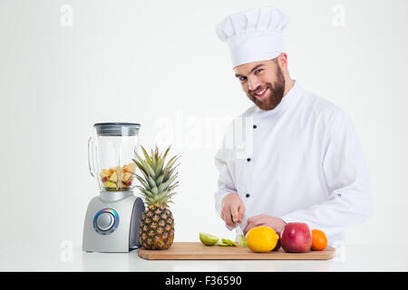 Portrait of a smiling male chef cuisiner fruits coupe isolé sur fond blanc Banque D'Images