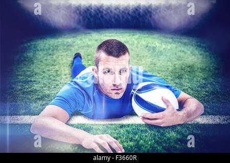 Image composite de joueur de rugby à la route en position couchée à l'avant avec ball Banque D'Images