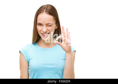 Portrait d'une femme montrant ok sign and smiling isolé sur fond blanc. Banque D'Images