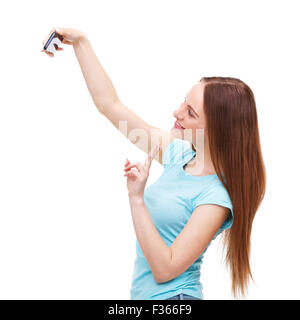 Belle jeune femme de prendre une photo d'elle-même avec son téléphone portable - isolé sur fond blanc. Banque D'Images