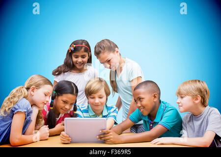 Image composite de cute pupils using tablet computer in library Banque D'Images