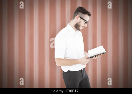 Image composite de geeky jeune homme de la lecture du livre noir Banque D'Images