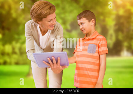 Image composite montrant des enseignants d'un comprimé à l'élève à bibliothèque Banque D'Images