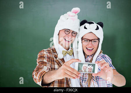 Image composite de hipster geek couple avec selfies smart phone Banque D'Images