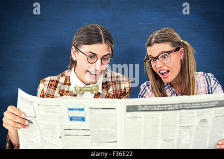 Image composite de geeky hipsters lire le journal Banque D'Images