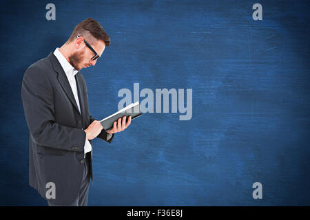 Image composite de geeky jeune homme de la lecture du livre noir Banque D'Images