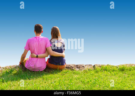 Young Love couple assis sur un pré vert Banque D'Images