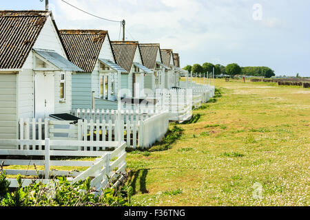 Une rangée de chalets de vacances en bois blanc avec des piquets de clôtures vers Dunster Beach.. Somerset, Angleterre, Royaume-Uni Banque D'Images