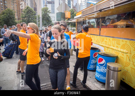 Des centaines d'échantillons de manger Panda Express' Poulet Orange signature à un évènement promotionnel à Columbus Circle à New York le dimanche, Septembre 27, 2015. Panda Express, omniprésents dans les centres commerciaux et les aéroports, a un projet d'expansion dans New York avec deux branches l'ouverture le mois prochain avec un troisième prévue plus tard dans l'année. Le restaurant est une propriété privée et possède 1800 magasins dans le monde entier. (© Richard B. Levine) Banque D'Images