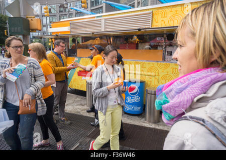 Des centaines d'échantillons de manger Panda Express' Poulet Orange signature à un évènement promotionnel à Columbus Circle à New York le dimanche, Septembre 27, 2015. Panda Express, omniprésents dans les centres commerciaux et les aéroports, a un projet d'expansion dans New York avec deux branches l'ouverture le mois prochain avec un troisième prévue plus tard dans l'année. Le restaurant est une propriété privée et possède 1800 magasins dans le monde entier. (© Richard B. Levine) Banque D'Images