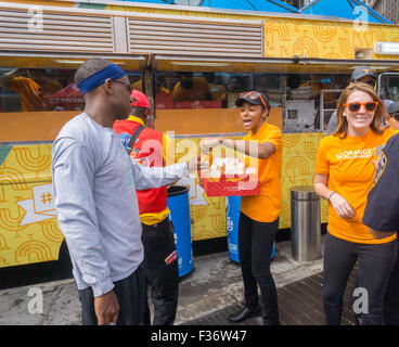 Des centaines d'échantillons de manger Panda Express' Poulet Orange signature à un évènement promotionnel à Columbus Circle à New York le dimanche, Septembre 27, 2015. Panda Express, omniprésents dans les centres commerciaux et les aéroports, a un projet d'expansion dans New York avec deux branches l'ouverture le mois prochain avec un troisième prévue plus tard dans l'année. Le restaurant est une propriété privée et possède 1800 magasins dans le monde entier. (© Richard B. Levine) Banque D'Images