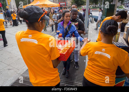 Des centaines d'échantillons de manger Panda Express' Poulet Orange signature à un évènement promotionnel à Columbus Circle à New York le dimanche, Septembre 27, 2015. Panda Express, omniprésents dans les centres commerciaux et les aéroports, a un projet d'expansion dans New York avec deux branches l'ouverture le mois prochain avec un troisième prévue plus tard dans l'année. Le restaurant est une propriété privée et possède 1800 magasins dans le monde entier. (© Richard B. Levine) Banque D'Images