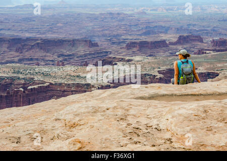 Un female hiker donne sur un vaste canyon sur une randonnée dans l'Utah Banque D'Images