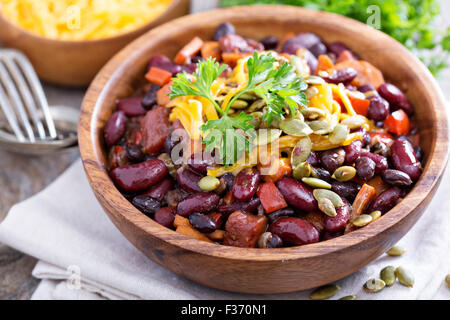 Chili végétarien avec haricots rouges et noirs, cheddar et graines de citrouille Banque D'Images