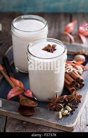 Lait moussé chaud avec le sirop et les épices d'hiver Banque D'Images