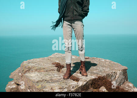 Jeune femme se tient debout sur une falaise au bord de la mer Banque D'Images