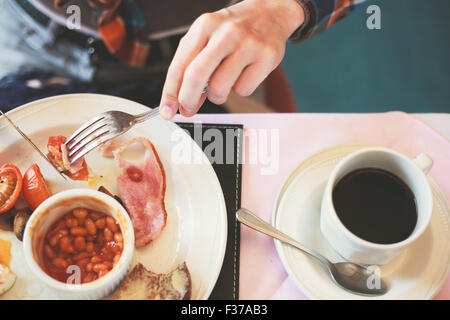 Gros plan sur les mains d'une jeune femme comme elle est de prendre le petit déjeuner Banque D'Images