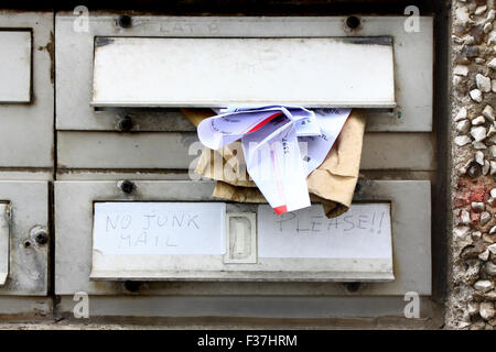 Junk mail fourré dans une boîte aux lettres de l'appartement, tandis qu'un autre propriétaire de l'appartement a laissé des instructions pour aucun courrier indésirable. Banque D'Images