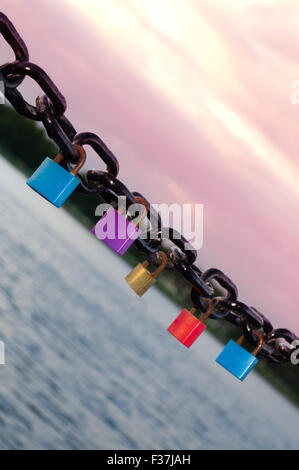 Cadenas de couleur différente pendu à une chaîne noire Banque D'Images