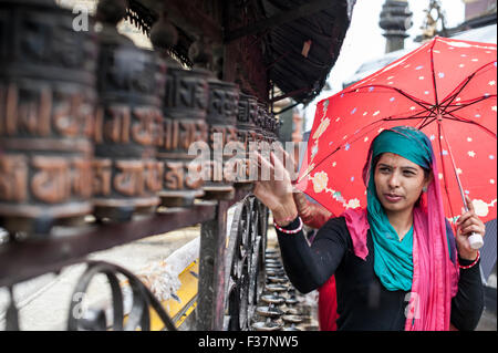 Une dame en prière avec wheles prier au Temple de Swayambhunath Kathmandou, Népal Banque D'Images