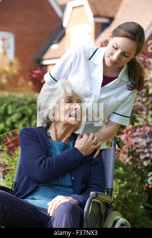 Carer poussant Senior Woman in Wheelchair Banque D'Images