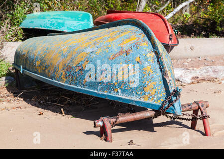 Vieux chaloupes jeter sur la côte de sable. Golfe de Finlande, Russie Banque D'Images