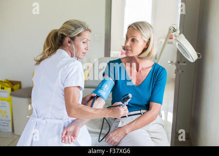 Contrôle de la pression artérielle médecin d'une femme. Banque D'Images