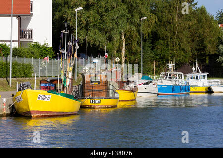 Des bateaux de pêche et de petits navires blancs et bleus amarrés ensemble dans le port de Rowy, en Pologne. Banque D'Images