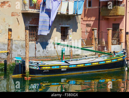 Péniche amarrée au bord du canal de couleur en dessous des appartements avec lave-hanging out Chioggia Lagune de Venise Vénétie Italie Europe Banque D'Images