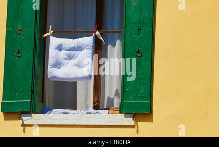 Sur la ligne de lavage Coussin fixé à l'extérieur de la fenêtre aux volets verts Chioggia Lagune de Venise Vénétie Italie Europe Banque D'Images