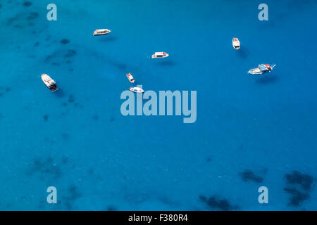 Photo aérienne de plusieurs bateaux ancrés dans une baie de la mer peu profonde avec de l'eau bleu clair. L'eau est assez propre pour permettre de voir th Banque D'Images