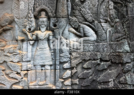 Fragment d'un mur en pierre sculpté à l'ancien temple de Bayon. Parc archéologique d'Angkor, province de Siem Reap, Cambodge. Banque D'Images