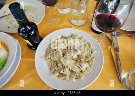 Une assiette de raviolis à la viande d'âne et un verre de vin rouge. Banque D'Images