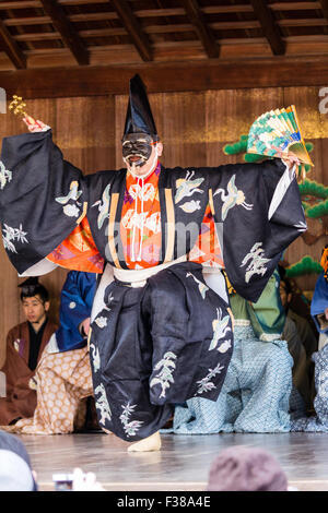 Kyoto, temple shintoïste Yasaka Nô traditionnel, la performance. L'acteur principal, Shite, Dancing with no-masque, no-men ou omote, whiling holding ventilateur, obi. À l'extérieur. Banque D'Images