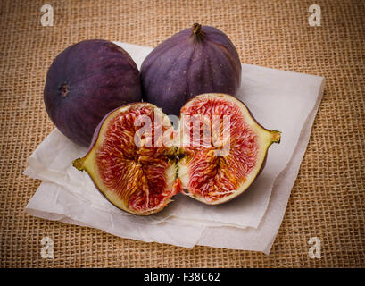 Trois figues mûres sur papier cuisson background, Close up, vue du dessus Banque D'Images