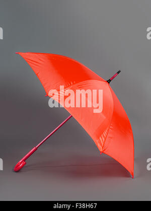 Ouvert parapluie rouge isolé sur fond gris Banque D'Images