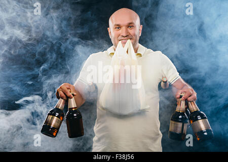 Homme heureux avec beaucoup de bière sur un fond noir Banque D'Images